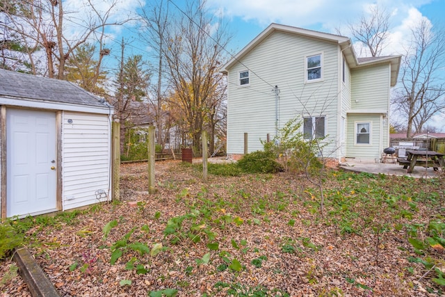 rear view of house with a storage shed and a patio