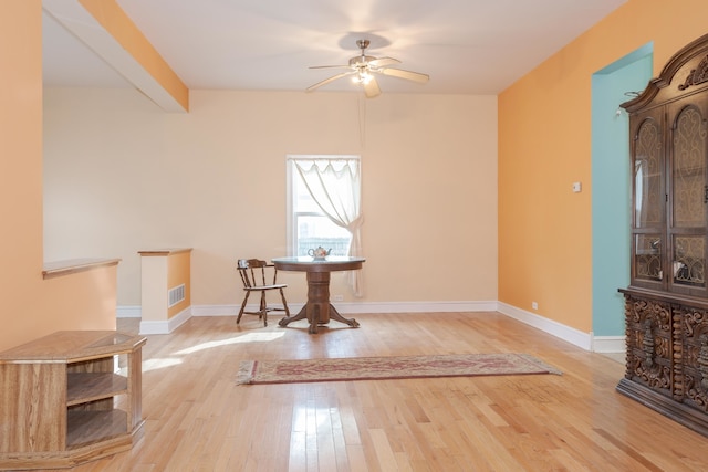 dining room with beam ceiling, light wood-type flooring, and ceiling fan