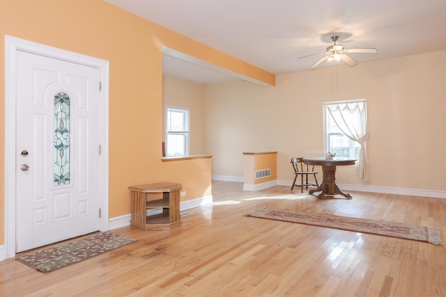 entryway with beamed ceiling, ceiling fan, and light hardwood / wood-style flooring