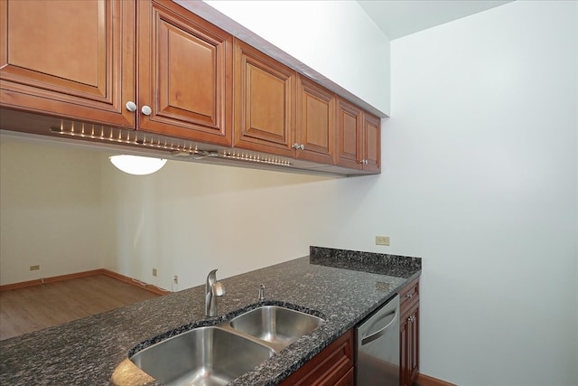 kitchen with hardwood / wood-style floors, dark stone countertops, sink, and dishwasher