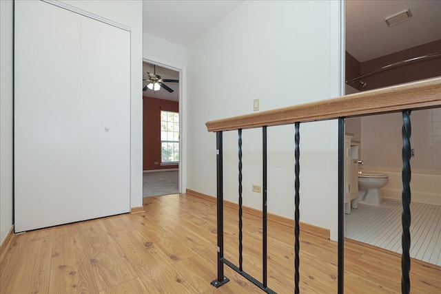 stairway featuring wood-type flooring and ceiling fan