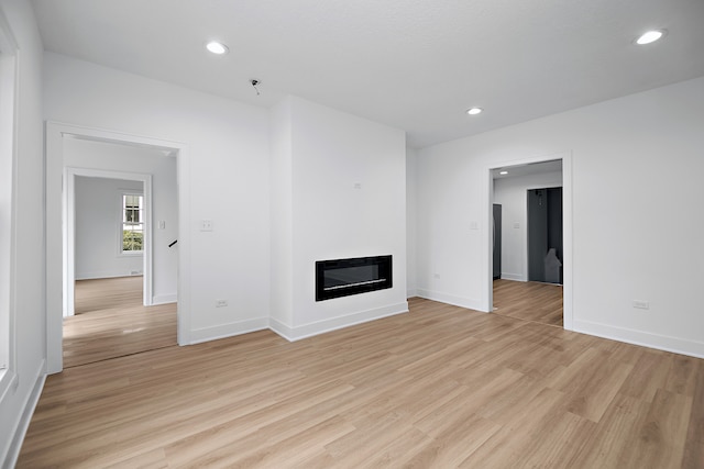 unfurnished living room with light wood-type flooring and heating unit