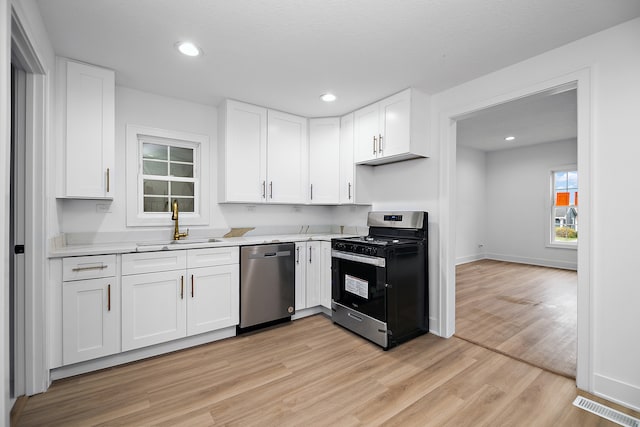 kitchen featuring light hardwood / wood-style floors, white cabinetry, sink, and appliances with stainless steel finishes