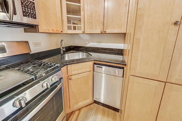 kitchen with appliances with stainless steel finishes, sink, light brown cabinetry, and light hardwood / wood-style flooring