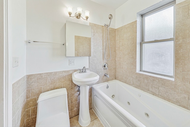 bathroom featuring tile patterned floors, tiled shower / bath, toilet, and tile walls