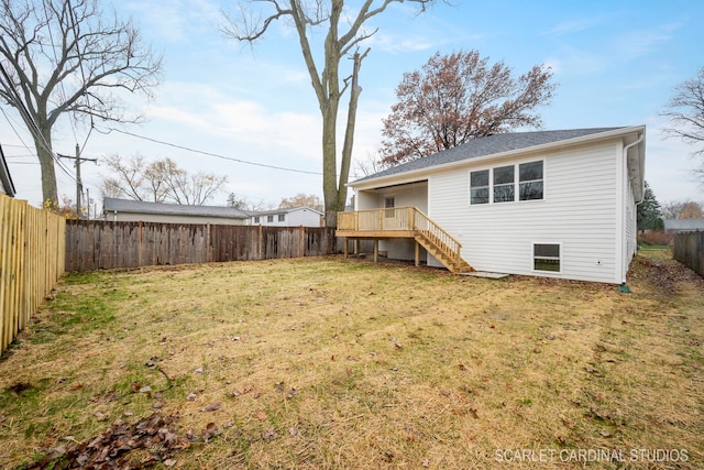 back of property featuring a wooden deck and a lawn