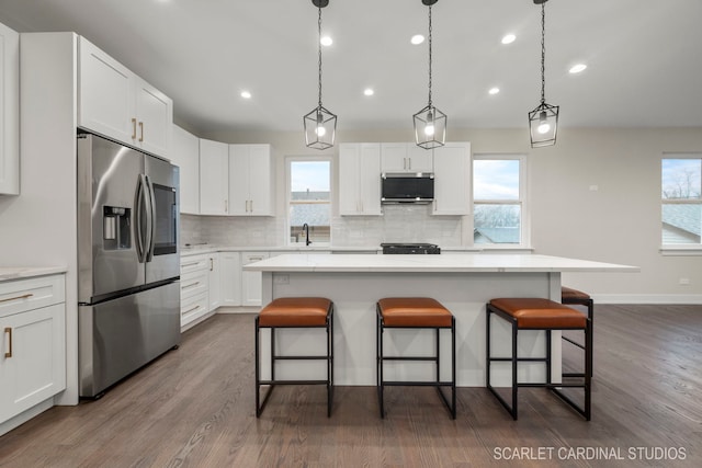 kitchen with dark hardwood / wood-style floors, a center island, white cabinetry, and appliances with stainless steel finishes