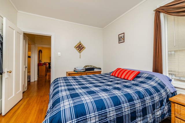 bedroom featuring ornamental molding and hardwood / wood-style flooring