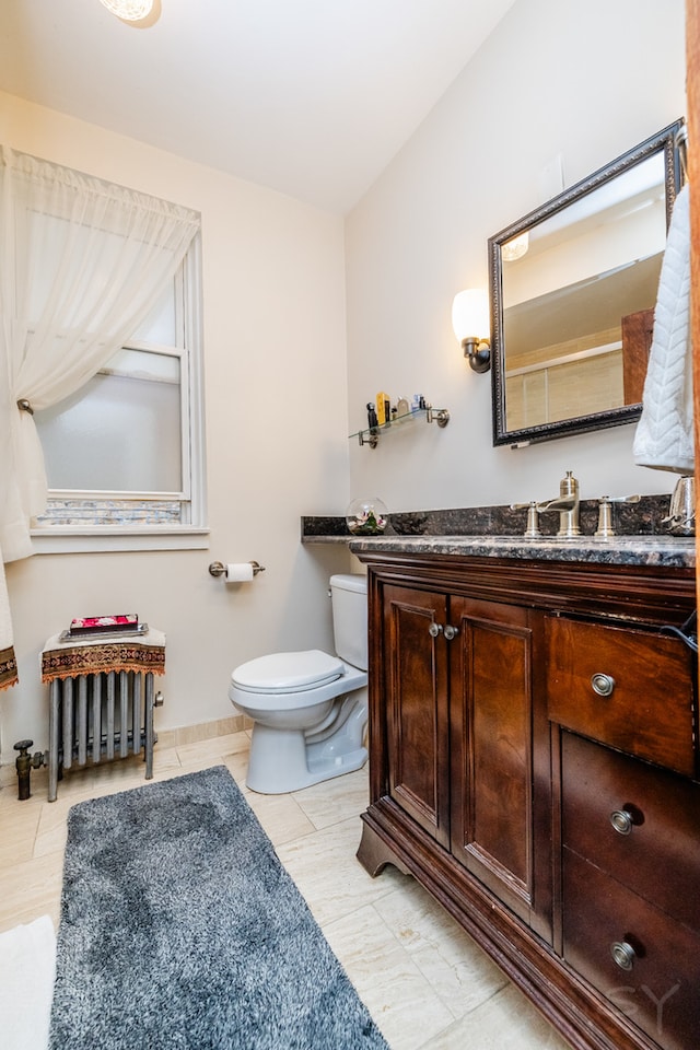 bathroom featuring vanity, toilet, tile patterned flooring, and radiator