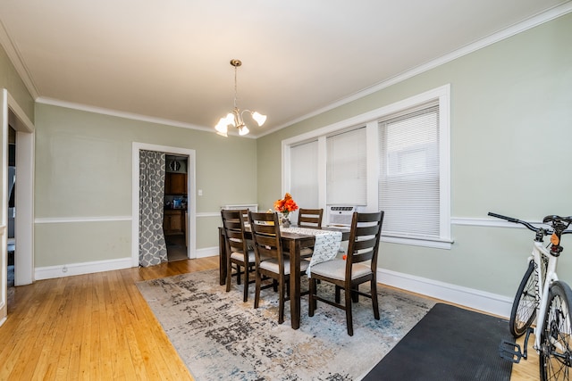 dining area featuring hardwood / wood-style flooring, ornamental molding, and an inviting chandelier