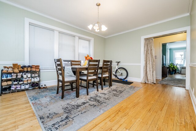 dining room featuring crown molding, hardwood / wood-style flooring, and a chandelier