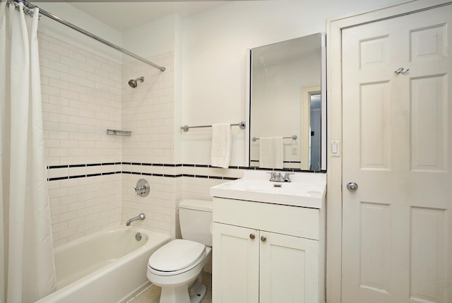 full bathroom featuring toilet, shower / tub combo, vanity, and tile walls