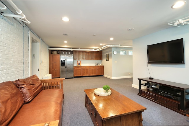 carpeted living room with baseboards, brick wall, and recessed lighting