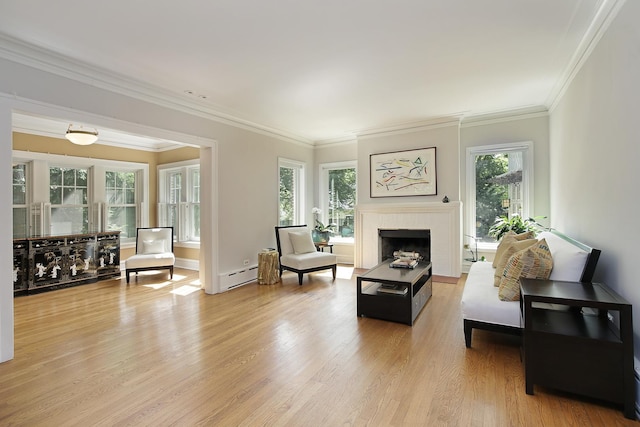 sitting room with a baseboard heating unit, a brick fireplace, light wood-style flooring, and crown molding