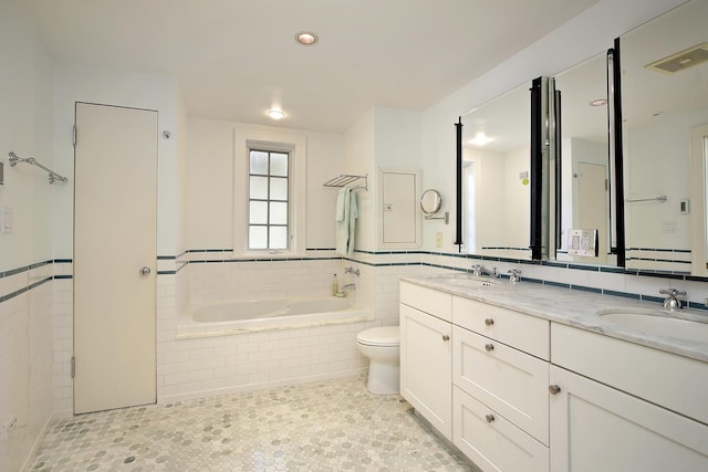 full bath featuring visible vents, double vanity, a sink, and toilet