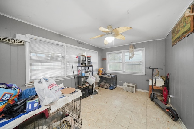 miscellaneous room with wood walls, ceiling fan, and ornamental molding