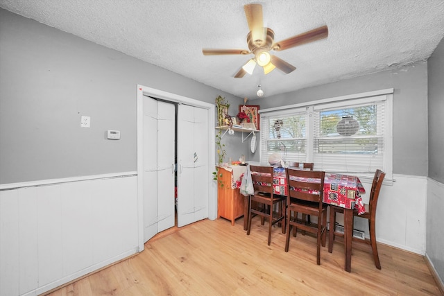 dining space featuring hardwood / wood-style flooring, ceiling fan, and a textured ceiling