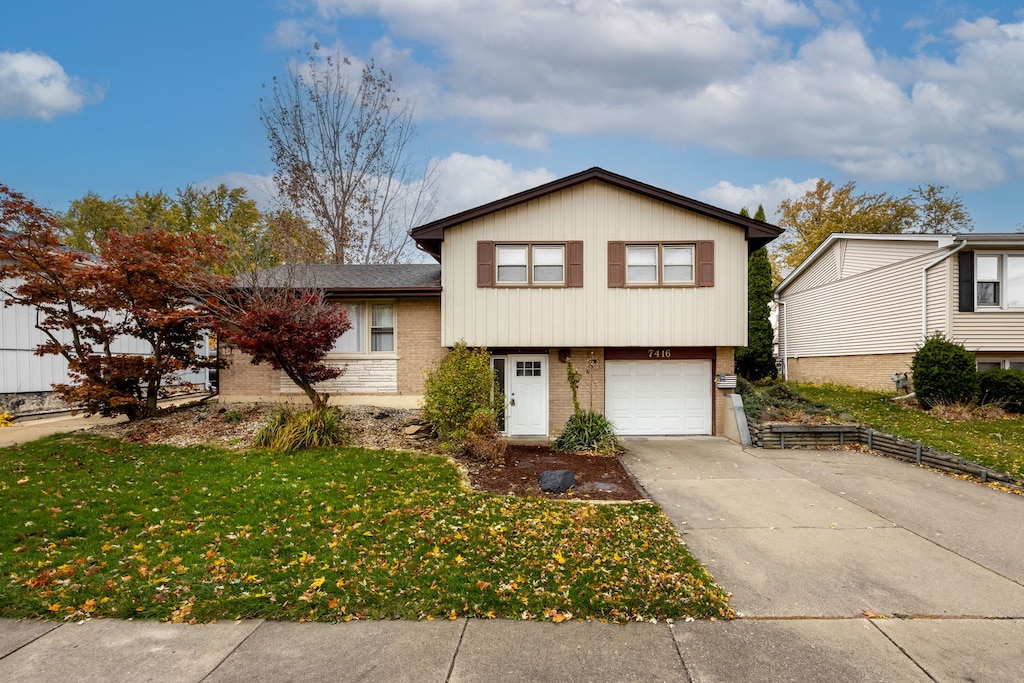 split level home featuring a garage and a front yard