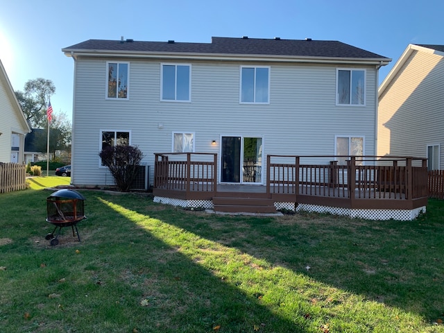 rear view of property featuring a lawn and a wooden deck