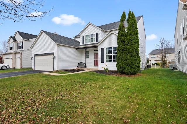 front facade with central AC unit, a garage, and a front lawn