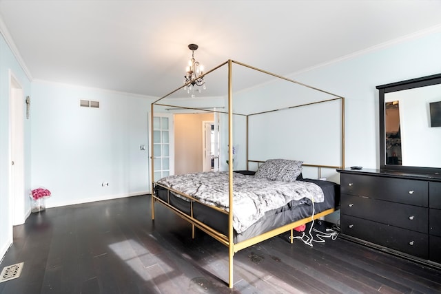 bedroom with dark hardwood / wood-style flooring, an inviting chandelier, and ornamental molding