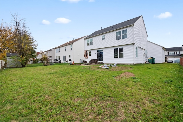 rear view of property featuring a lawn