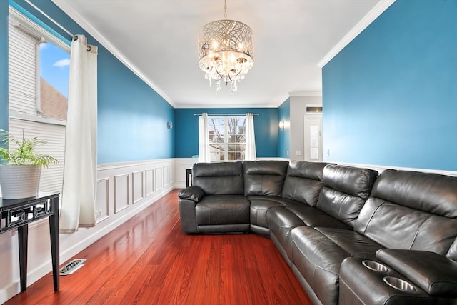 living room featuring crown molding, wood-type flooring, and a notable chandelier