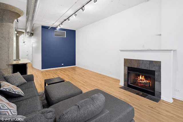 living room featuring hardwood / wood-style flooring, a fireplace, and track lighting