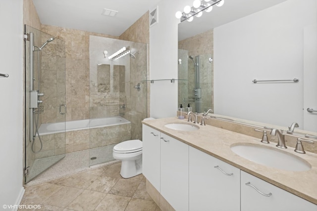 full bathroom featuring tile patterned floors, vanity, toilet, and bath / shower combo with glass door