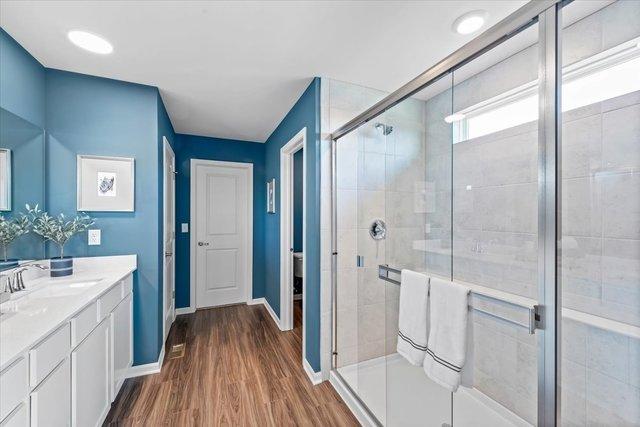 384 W Point Cir, Algonquin, IL 60102 - bathroom featuring vanity, a stall shower, wood finished floors, and baseboards