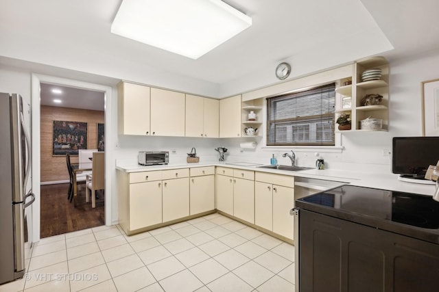 kitchen featuring sink, stainless steel refrigerator, and cream cabinets