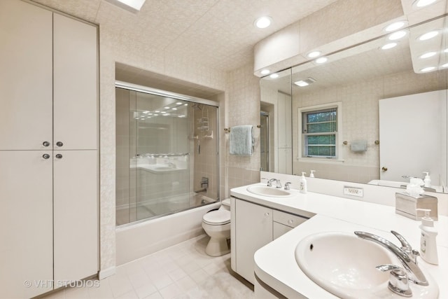 full bathroom with tile patterned flooring, vanity, toilet, and shower / bath combination with glass door