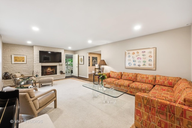 carpeted living room featuring a stone fireplace