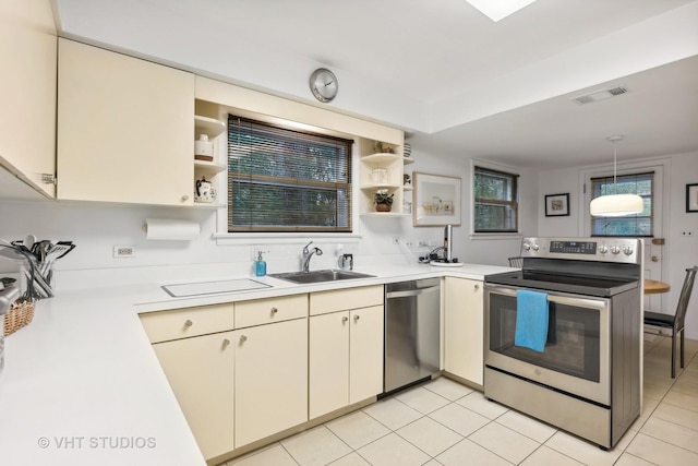 kitchen with kitchen peninsula, sink, light tile patterned floors, and stainless steel appliances