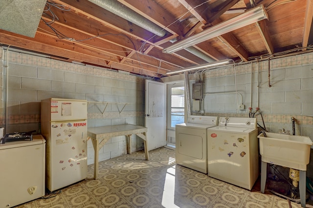 basement featuring independent washer and dryer and white fridge