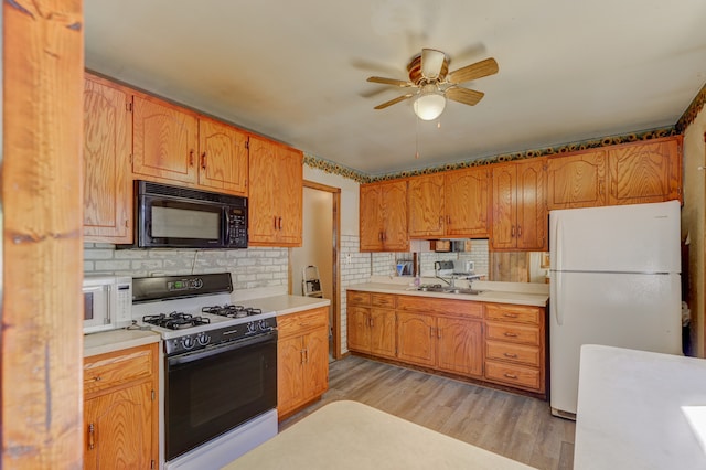 kitchen featuring decorative backsplash, sink, ceiling fan, light hardwood / wood-style flooring, and white appliances