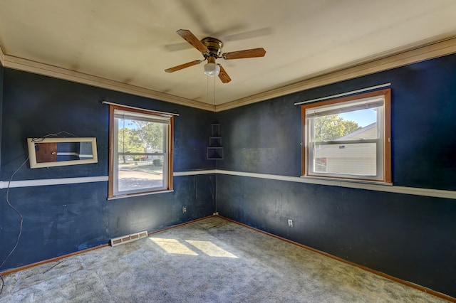 carpeted empty room featuring ceiling fan and ornamental molding