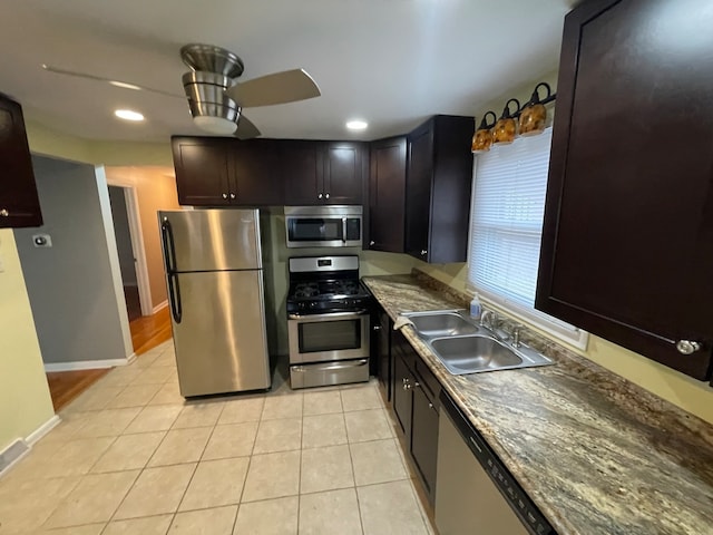 kitchen featuring sink, ceiling fan, light tile patterned flooring, dark brown cabinets, and appliances with stainless steel finishes