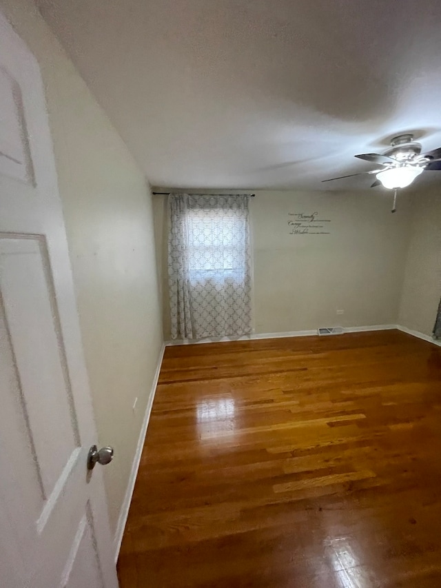 empty room featuring wood-type flooring and ceiling fan