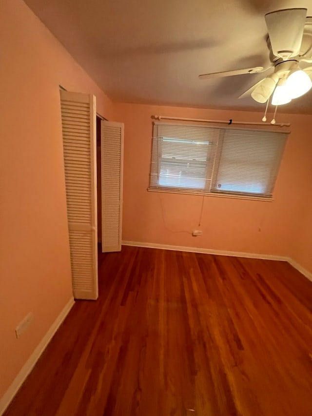 unfurnished bedroom with wood-type flooring, ceiling fan, and a closet