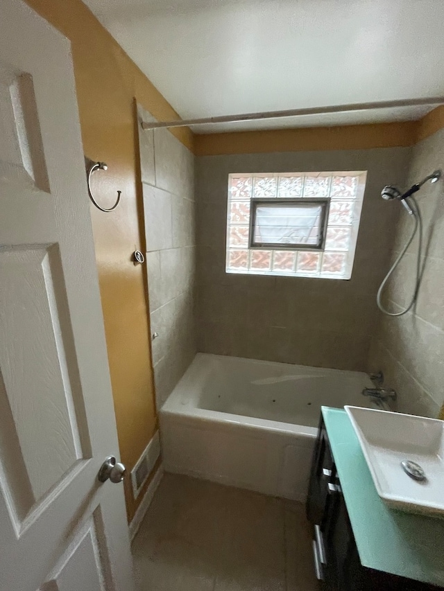 bathroom with tiled shower / bath combo and sink