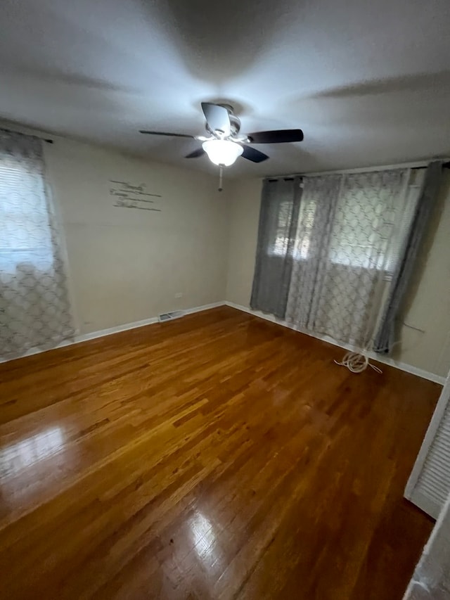 empty room with wood-type flooring and ceiling fan