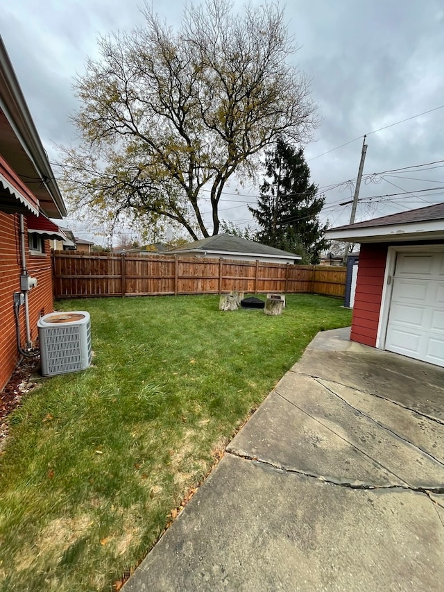 view of yard featuring a garage and cooling unit