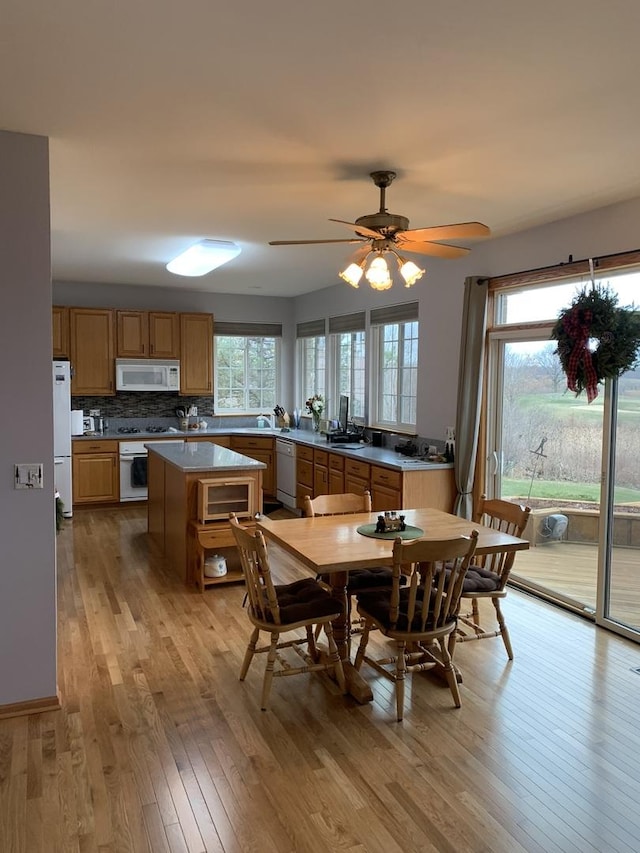 dining space with ceiling fan, plenty of natural light, sink, and light wood-type flooring