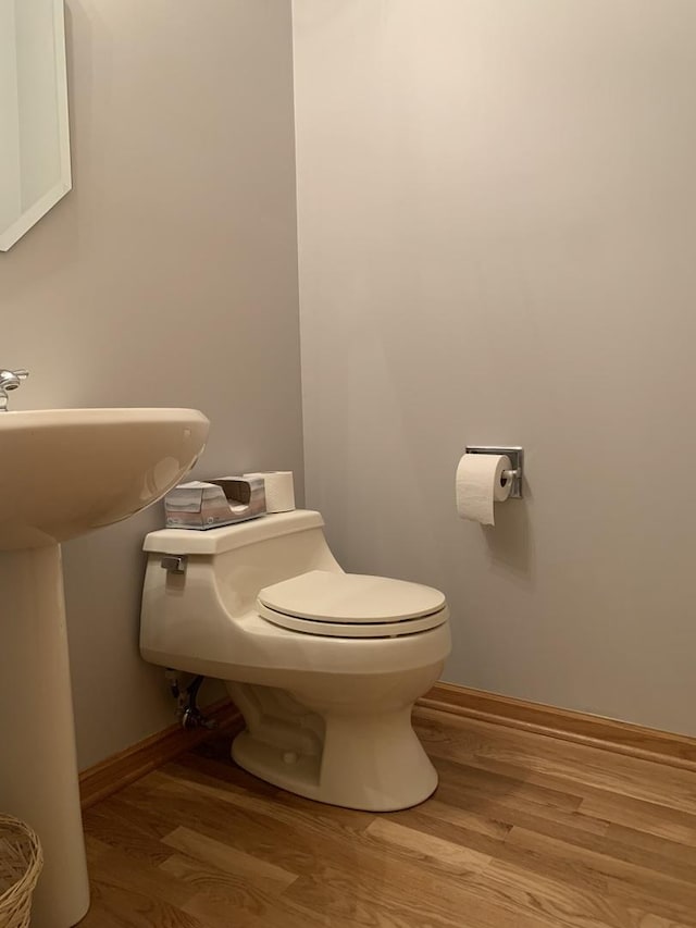 bathroom with hardwood / wood-style flooring and toilet