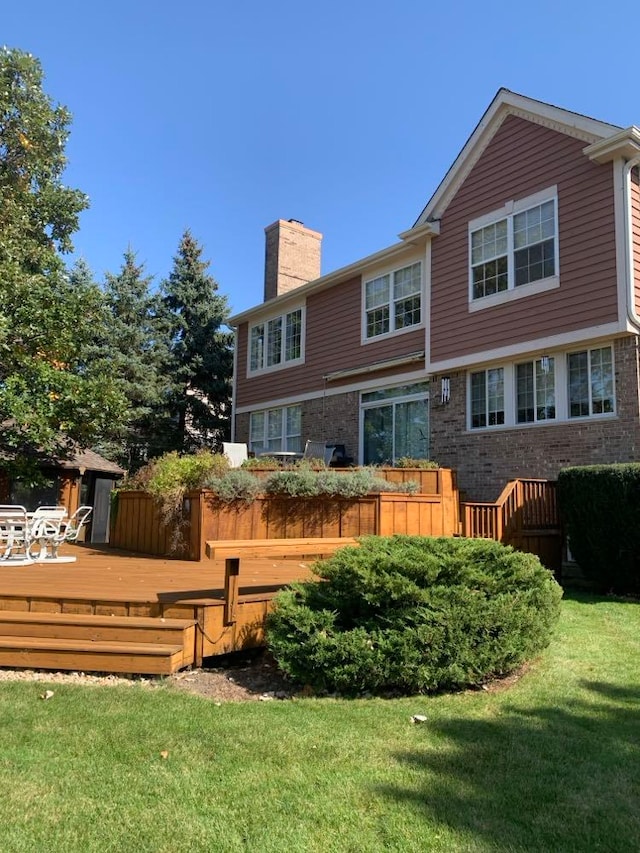 back of property featuring a yard and a wooden deck