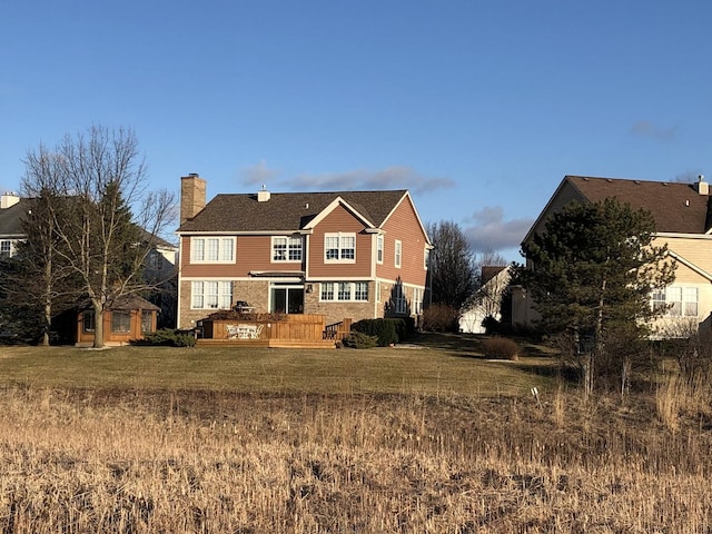 rear view of house featuring a yard and a deck