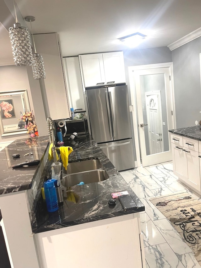 kitchen featuring white cabinets, hanging light fixtures, appliances with stainless steel finishes, and ornamental molding