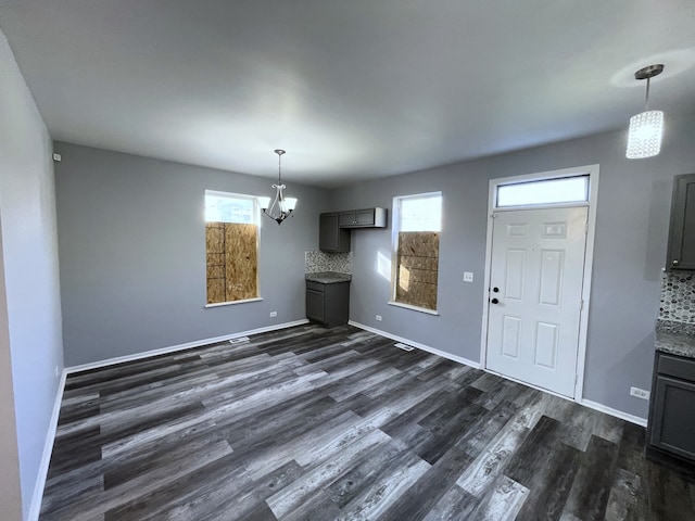 unfurnished dining area featuring dark wood-type flooring and a healthy amount of sunlight