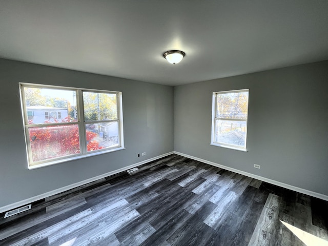 unfurnished room with dark hardwood / wood-style flooring